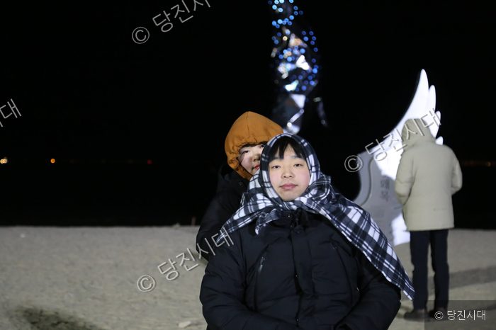 왜목마을 해변에서 시민들이 기념사진을 찍고 있다.