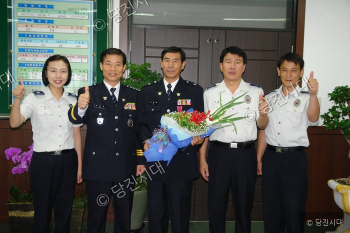경찰관들이 모범공무원으로 선정된 오만복 경위를 축하하며 기념 촬영을 하고 있다.