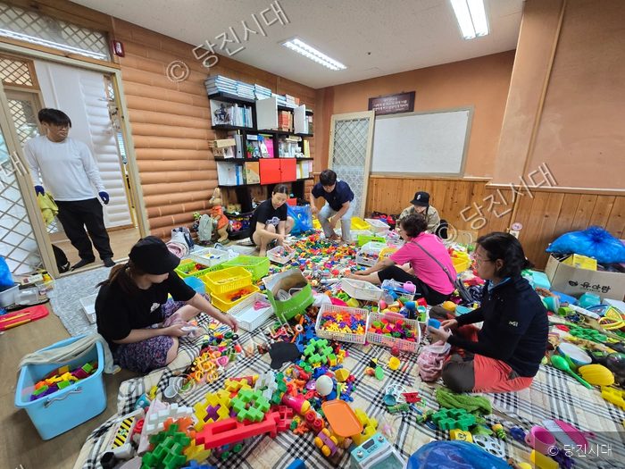자원봉사자들이 침수 피해를 입은 어린이집에서 장난감을 정리하고 있다.