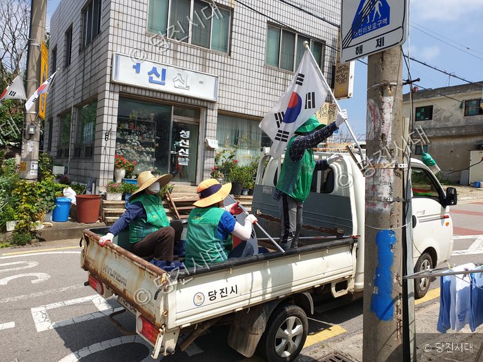 당진시 면천면에서 새마을운동 봉사자들이 차량을 타고 태극기를 흔들고 있다.