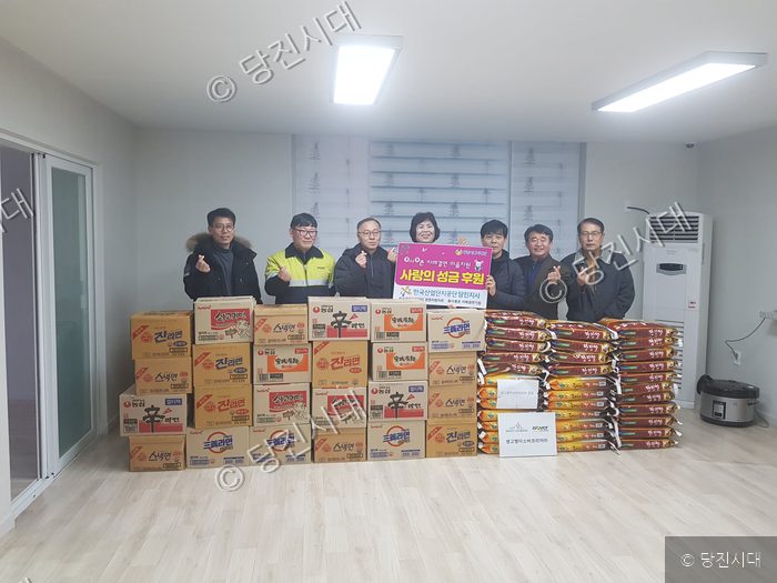 관계자들이 자매결연 마을에 사랑의 물품을 지원하고 기념 촬영을 하고 있다.