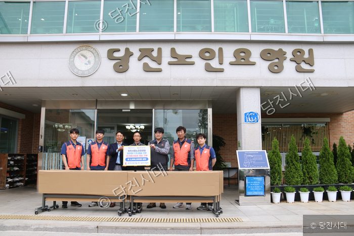 봉사자들이 당진시립노인요양원을 찾아 물품과 재능을 기부하고 기념촬영을 하고 있다.