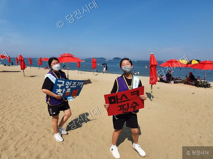 석문중학교 인터랙트 학생들이 해수욕장에서 안전 및 방역 캠페인을 벌이고 있다.