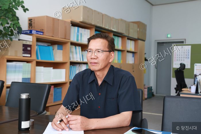 한 남성이 사무실에서 인터뷰를 위해 앉아 있다.
