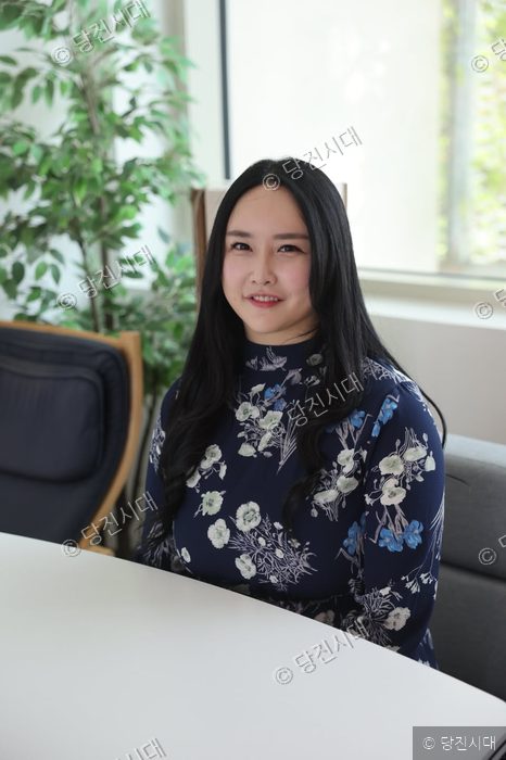 김주희 대표가 실내에서 카메라를 향해 미소 짓고 있다.