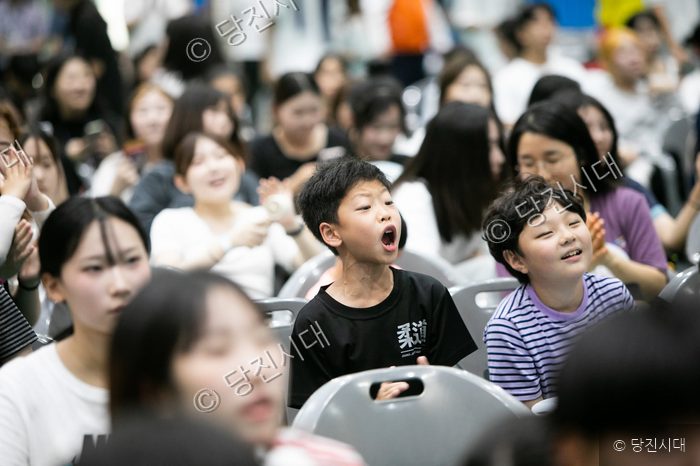청소년 축제에 참석한 아이들이 즐겁게 환호하고 있다.