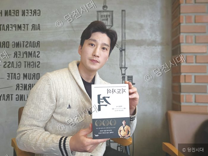 박강순 관장이 책을 들어 보이며 포즈를 취하고 있다.