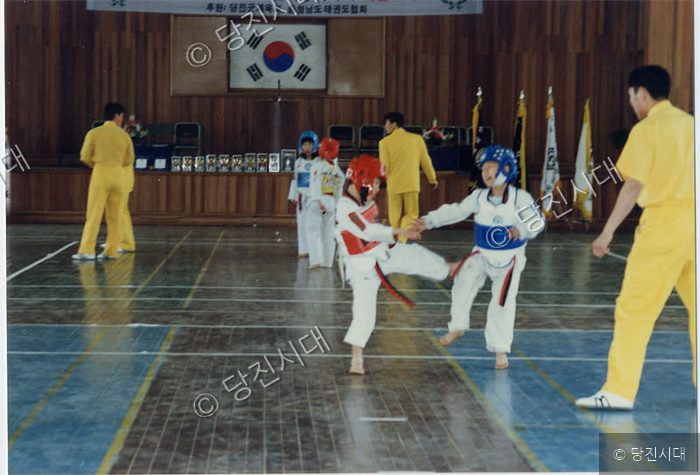 어린이들이 태권도 경기 대회에서 겨루기를 하고 있다.