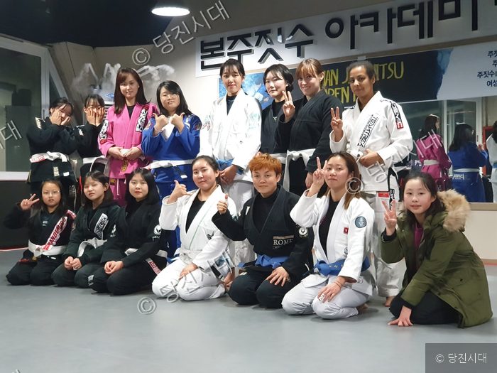 주짓수 도복을 입은 관원들이 모여 포즈를 취하고 있다.