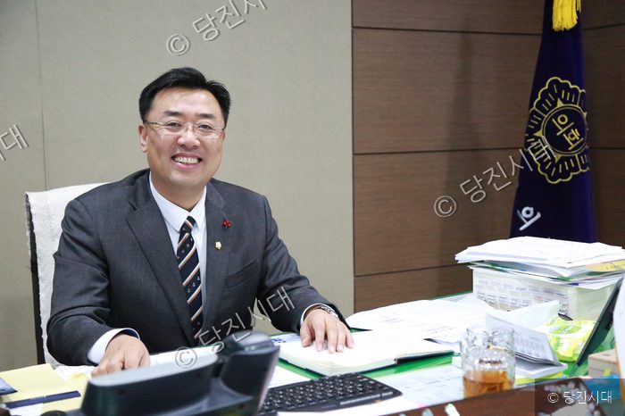 김기재 당진시의회 의장이 집무실에서 환하게 미소 짓고 있다.