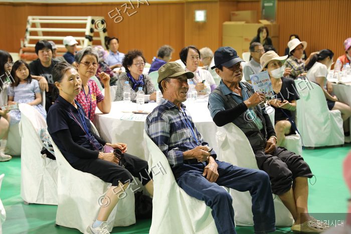 주민들이 송악읍 주민총회에 참석하여 행사를 지켜보고 있다.