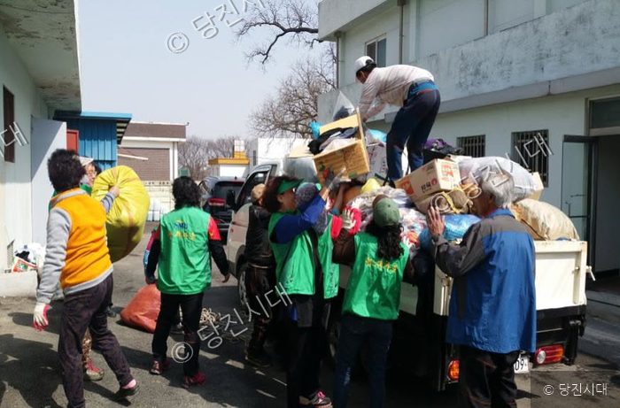 주민들과 새마을지도자들이 트럭에 물품을 싣고 있다.