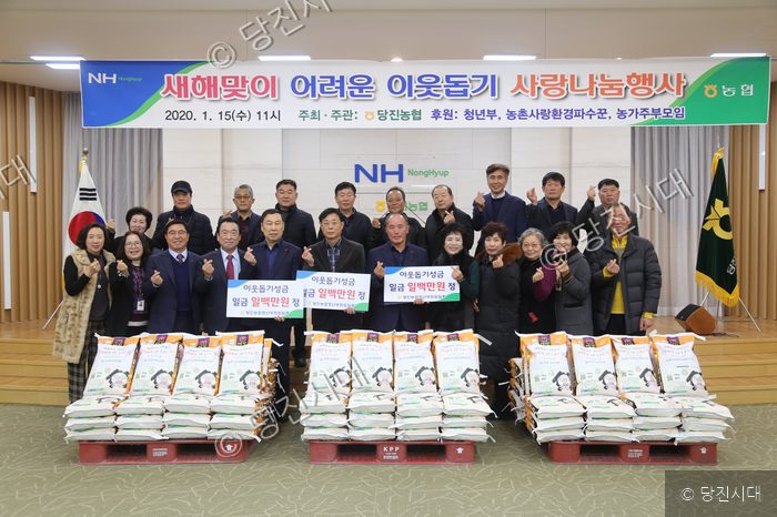 당진농협이 이웃돕기 성금과 쌀을 전달하며 기념 촬영을 하고 있다.