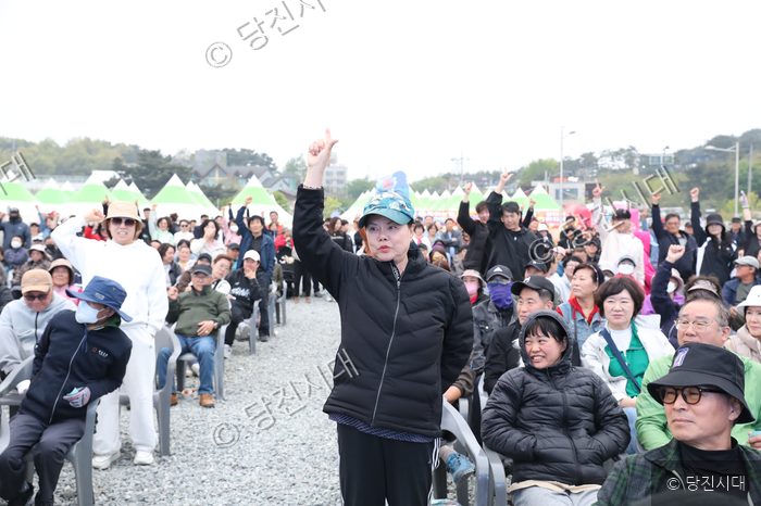 주민들이 장고항 실치 축제 현장에서 손을 들어 올리고 있다.