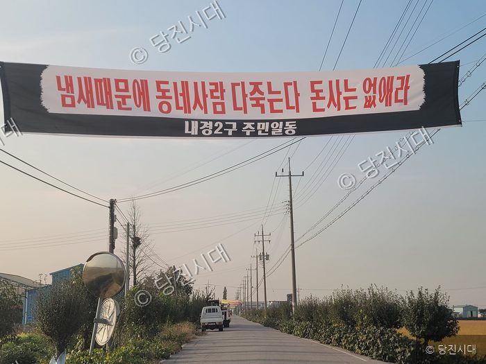 마을 길가에 돈사 철거를 요구하는 주민들의 현수막이 걸려 있다.