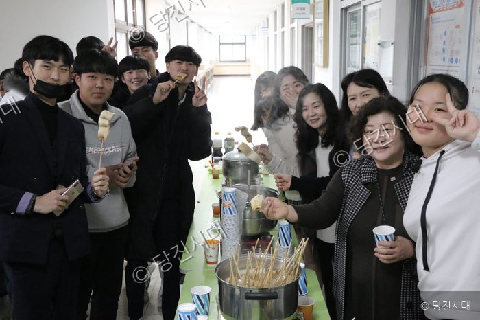 송악중학교 학생들이 낙토 문화 축제에서 어묵을 나누며 즐겁게 웃고 있다.