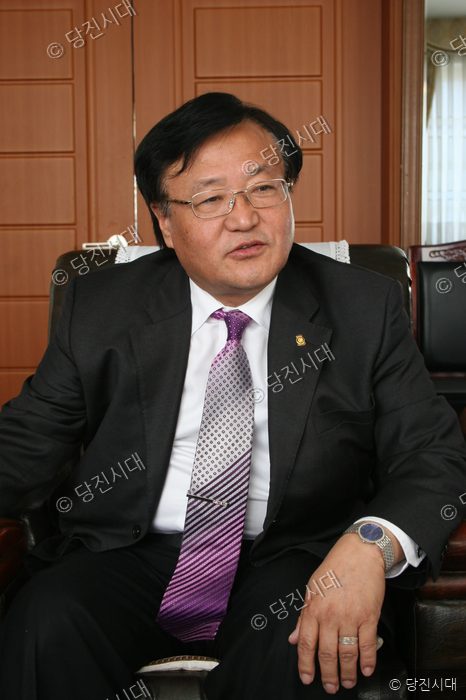 홍윤표 대호지면장이 의자에 앉아 카메라를 바라보고 있다.