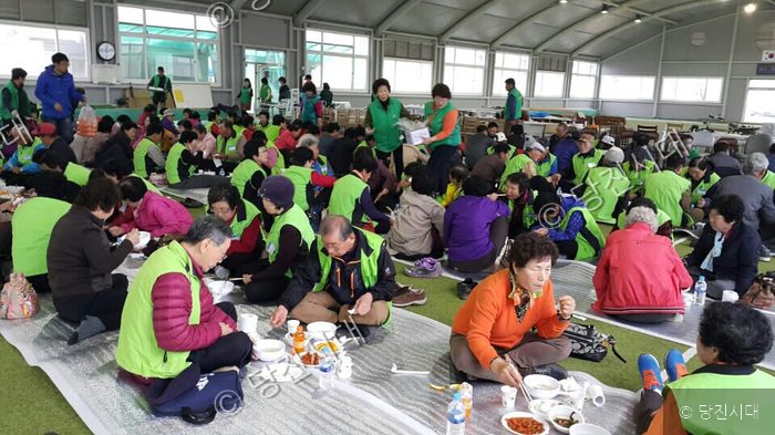 실내에서 많은 사람들이 모여 함께 식사를 나누고 있다.
