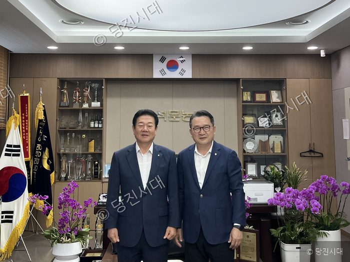석문농협 조합장과 농협무역 이사가 나란히 서서 기념 촬영을 하고 있다.