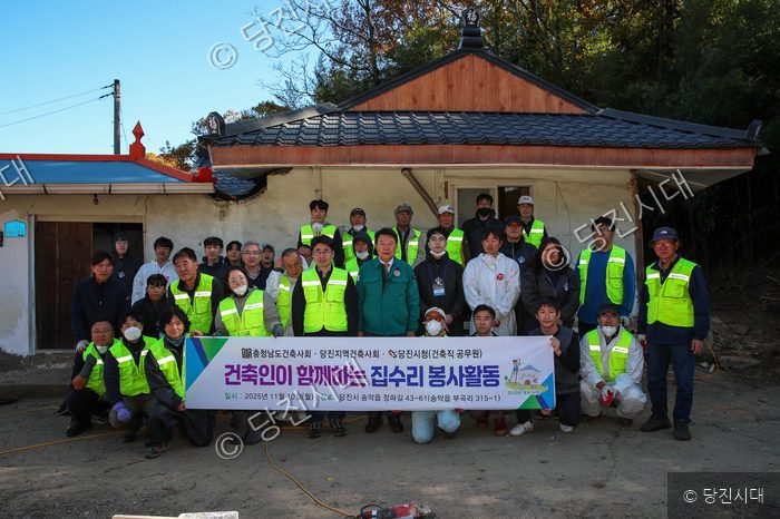 당진 지역 건축인들이 집수리 봉사활동을 기념해 단체 촬영을 하고 있다.