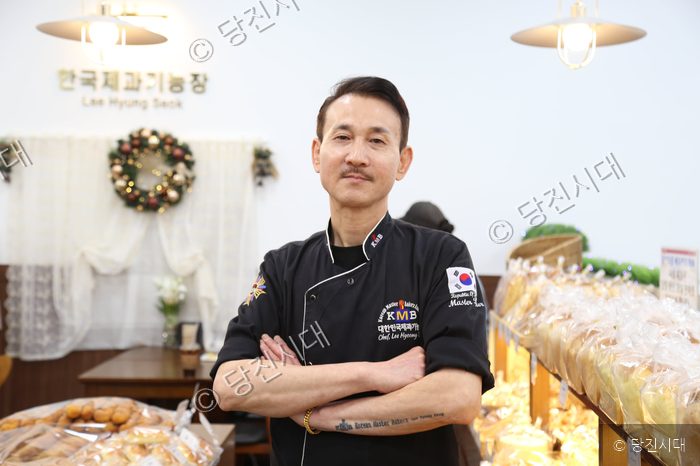 제과제빵 기능장인 대표가 매장에서 팔짱을 낀 채 포즈를 취하고 있다.