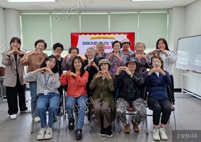 당진시남부노인복지관에서 어르신들과 강사들이 손하트를 만들고 있다.