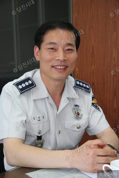 경찰서장이 인터뷰에 응하며 밝게 웃고 있다.