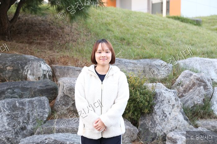 최고운 학생이 야외 정원에서 포즈를 취하고 있다.