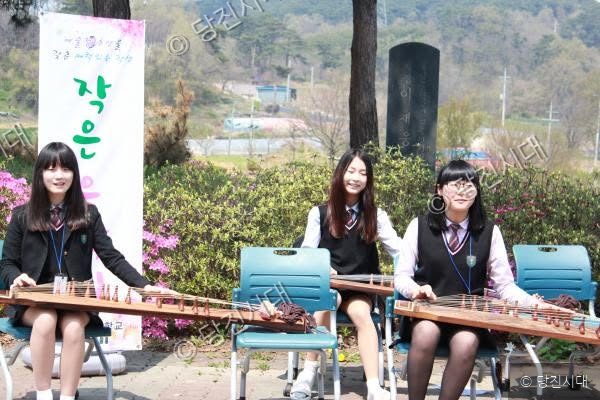 여학생들이 야외에서 가야금을 연주하고 있다.