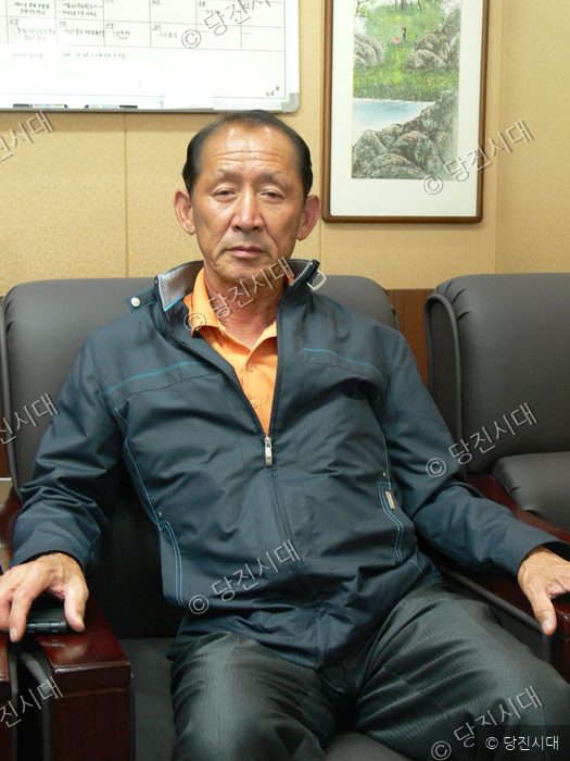 임긍순 송악면 반촌1리 이장이 의자에 앉아 카메라를 바라보고 있다.