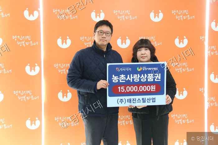 기부자가 농촌사랑상품권 기부 판을 들고 기념 촬영을 하고 있다.