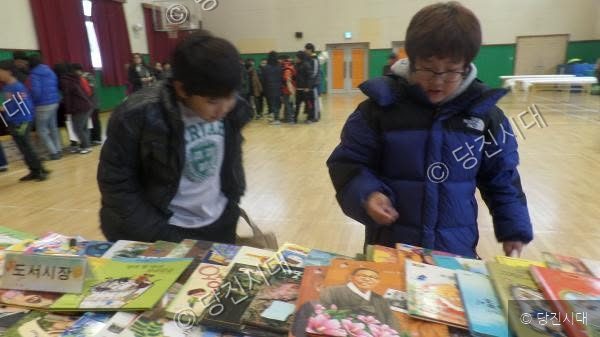 학생들이 체육관에서 열린 도서 행사에서 책을 살펴보고 있다.