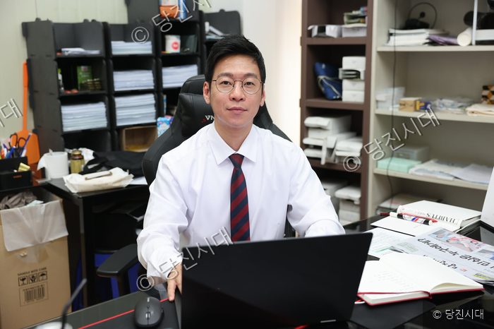 김성훈 대표가 사무실 책상에 앉아 카메라를 바라보고 있다.