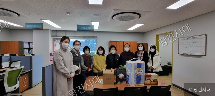 장애인단체 및 봉사단체 관계자들이 사무실에서 후원 물품을 전달하고 기념 촬영을 하고 있다.