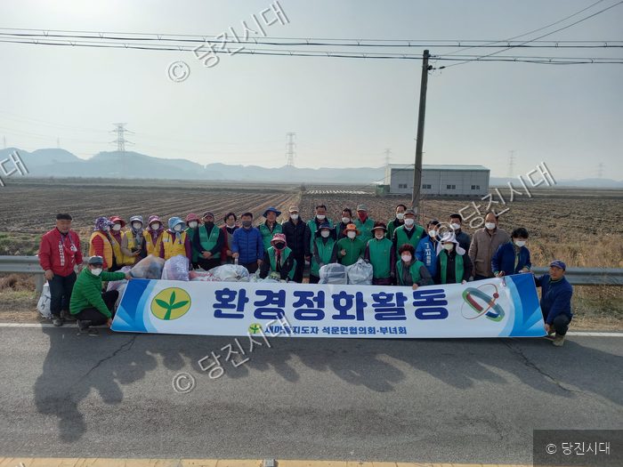 석문면 주민들이 환경정화 활동을 펼치고 기념 촬영을 하고 있다.