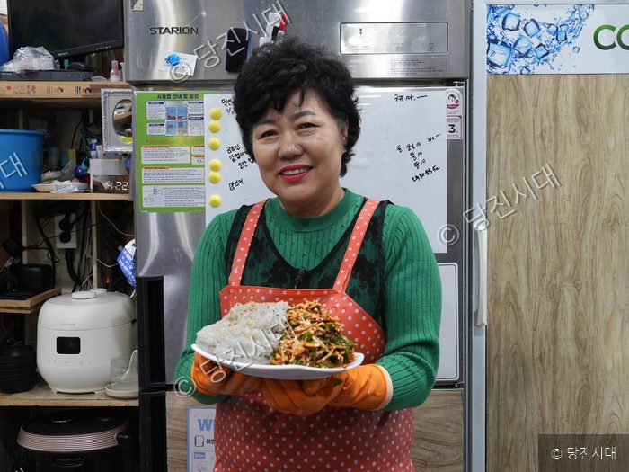이영옥 대표가 실치 요리가 담긴 접시를 들고 미소 짓고 있다