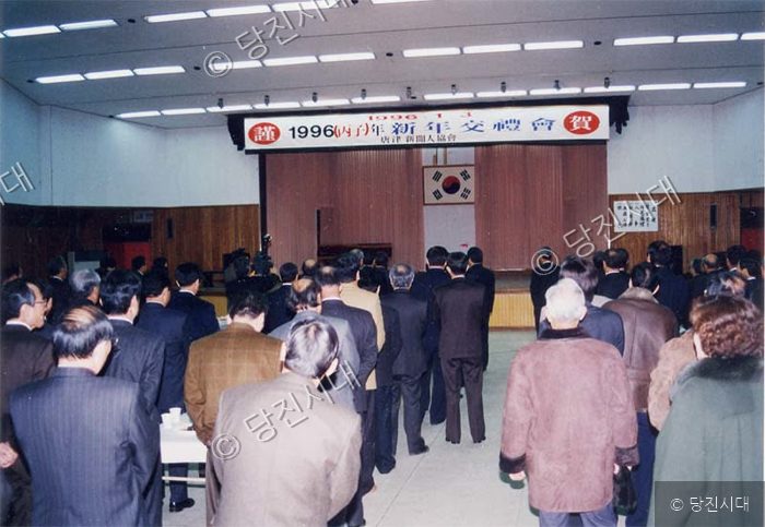 사람들이 강당에 모여 행사를 진행하고 있다.