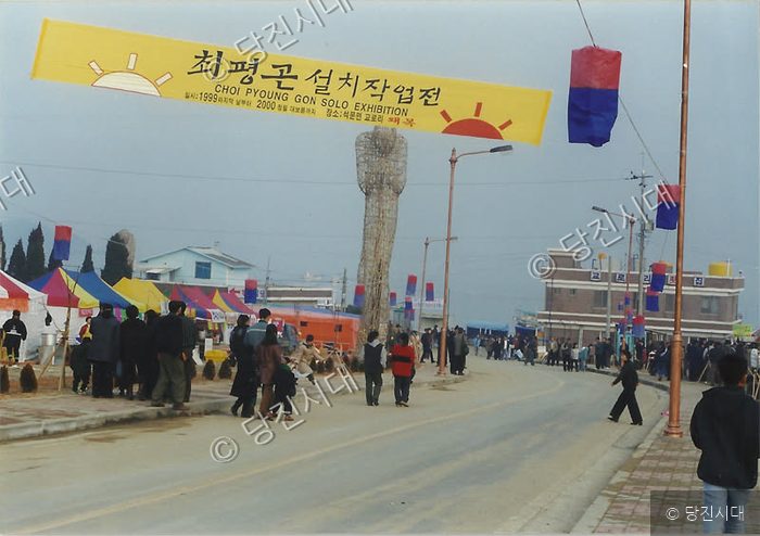 거리에서 사람들이 최평곤 설치작업전 전시를 구경하고 있다.