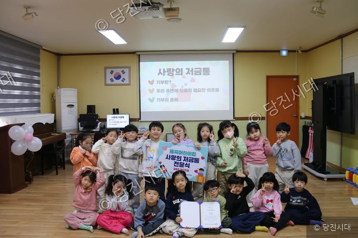 물곡어린이집 원생들이 사랑의 저금통 전달식을 하고 있다.