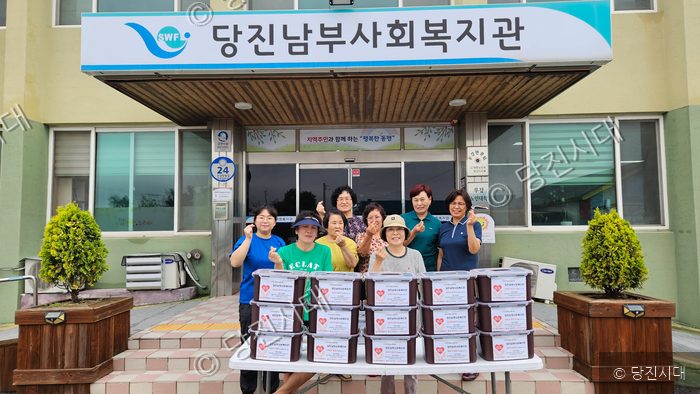 당진남부사회복지관 앞에서 자원봉사자들이 김치 나눔 행사를 하고 있다.