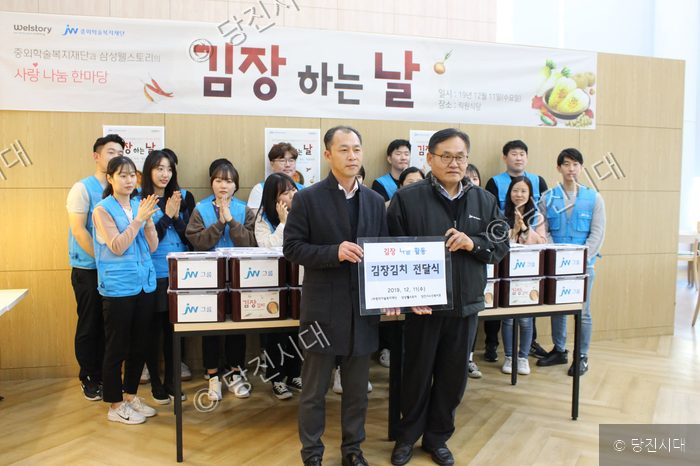 자원봉사자들이 김장김치 전달식 기념촬영을 하고 있다.