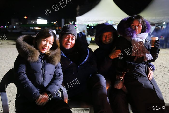 왜목마을 해맞이 현장에서 시민들이 모닥불을 쬐며 웃고 있다.