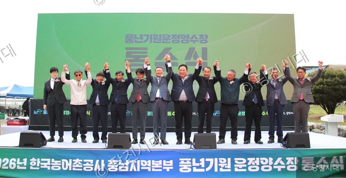 내외 귀빈들이 무대에 올라 통수식을 기념하며 손을 맞잡고 있다.