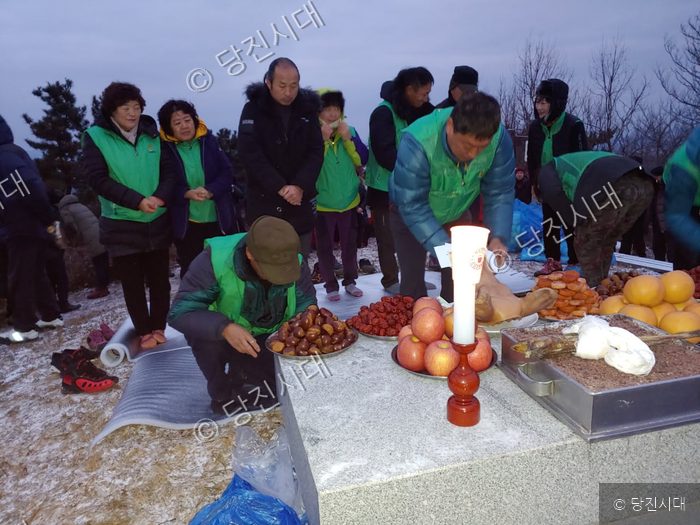 새마을지도자협의회 회원들이 야외에서 제사를 지내고 있다.