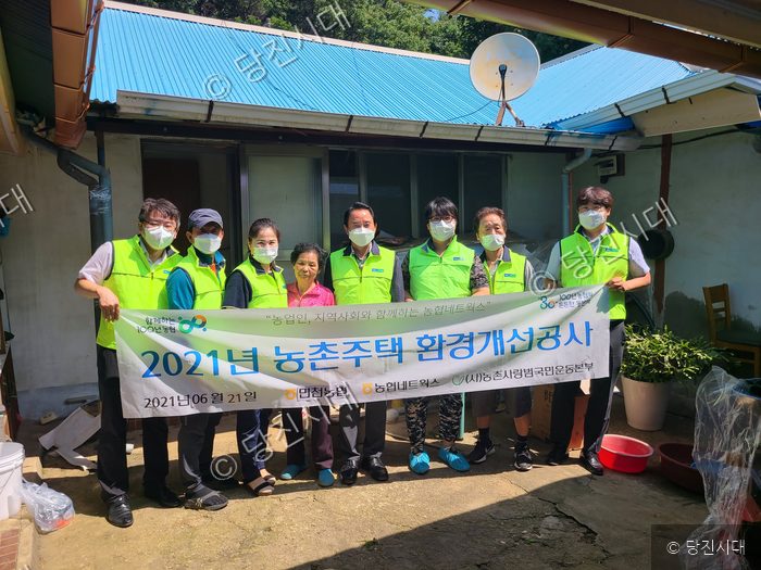 봉사자들이 농촌주택 환경개선공사를 기념하며 단체로 기념촬영을 하고 있다.