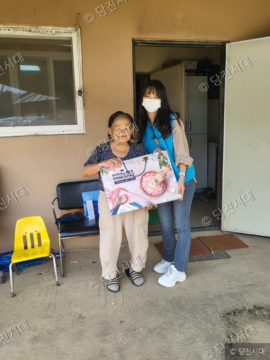 자원봉사자가 장애인 가정에 방문하여 추석 선물을 전달하고 있다.