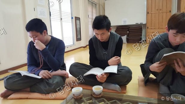 어린 학생들이 사찰에서 책을 읽으며 마음을 수양하고 있다.