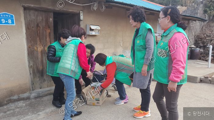 새마을운동 회원들이 당진의 한 주택을 찾아 물품을 전달하고 있다.