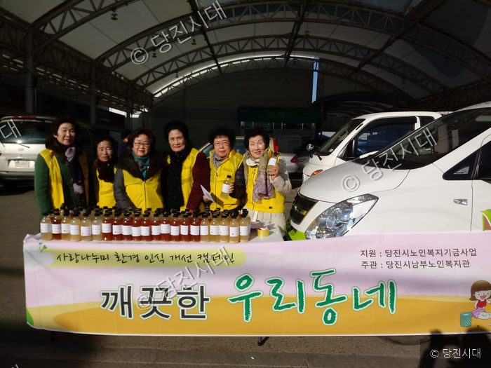 노인 봉사단원들이 깨끗한 우리동네 환경 캠페인 부스에서 기념 촬영을 하고 있다.