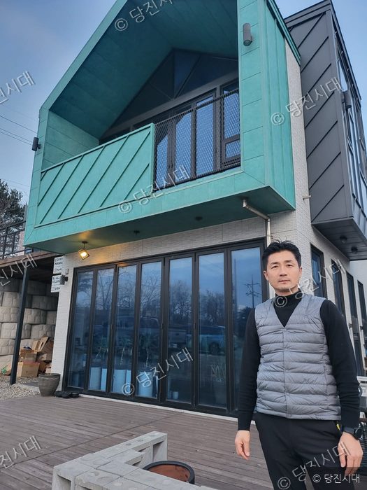 시곡동에 위치한 에스엠빌리지 건물 앞에서 대표가 포즈를 취하고 있다.